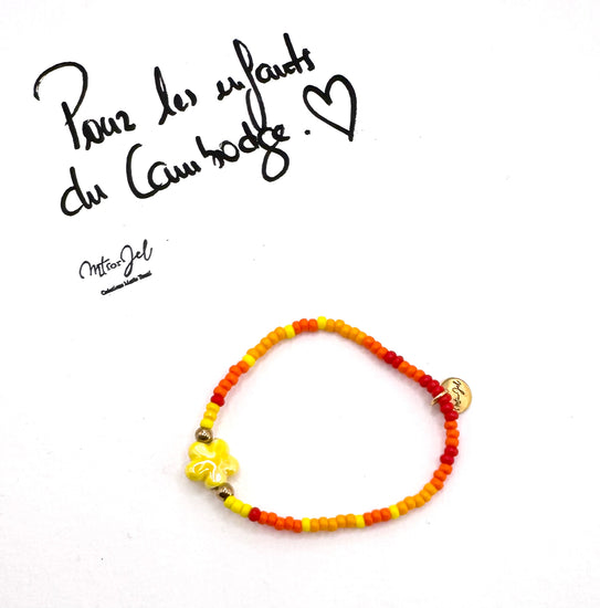 Capsule humanitaire pour les enfants du Cambodge.
Bracelet élastique pour les grandes et les petites - Perle fleur en céramique jaune - Perles de rocaille.