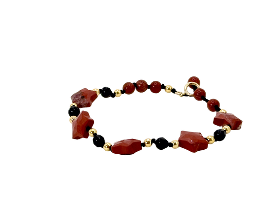 La simplicité fun du lien, la lumière des étoiles.

Bracelet sur cordon - Perles étoile en jaspe rouge - Perles d'onyx noire, jaspe rouge et en or laminé 14 carats.

J'ai noué chaque perle entre elles, comme un acte de solidarité et de compassion.