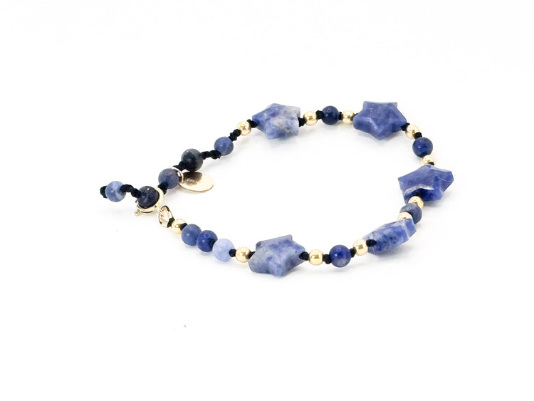 La simplicité fun du lien, la lumière des étoiles.

Bracelet sur cordon - Perles étoile en sodalite - Perles de sodalite et en or laminé 14 carats.

J'ai noué chaque perle entre elles, comme un acte de solidarité et de compassion.