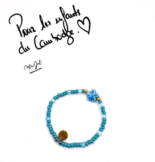 Capsule humanitaire pour les enfants du Cambodge.
Bracelet élastique pour les grandes et les petites - Perle fleur en céramique bleu - Perles de rocaille.