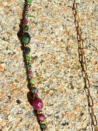 Vert, rose, or - des couleurs qui claquent et vibrent. Une pièce pleine d’énergie et de style.

Collier sur chaîne maille rectangle en or laminé - Pendentif "goutte" de 6 cm en rubis zoïsite et breloque rayon de soleil en or laminé - Perles de rubis zoïsite et en or laminé 14 carats.